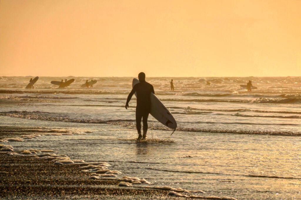 Surfer genießen die Wellen am Nordseestrand