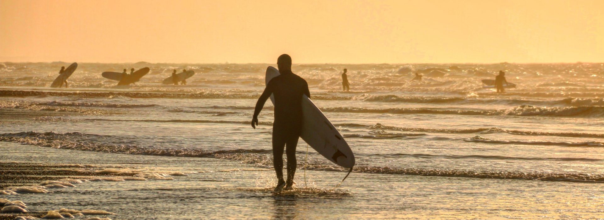 Surfer genießen die Wellen am Nordseestrand